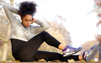 Young woman exercising in park representing wellness promoted through employee benefits programs