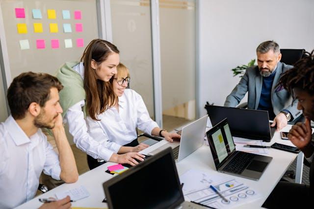 A team of colleagues working together in an office while discussing employee benefits plans